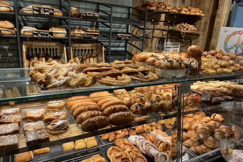 Vitrine de boulangerie garnie de croissants, pains au chocolat, brioches et pains artisanaux