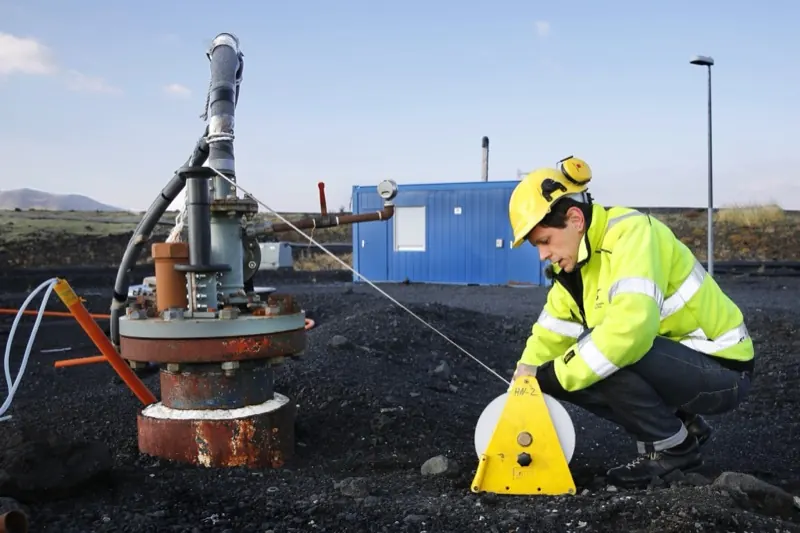 Technicien équipé d'un casque, d'un casque anti-bruit et d'un gilet haute visibilité intervenant sur une installation industrielle