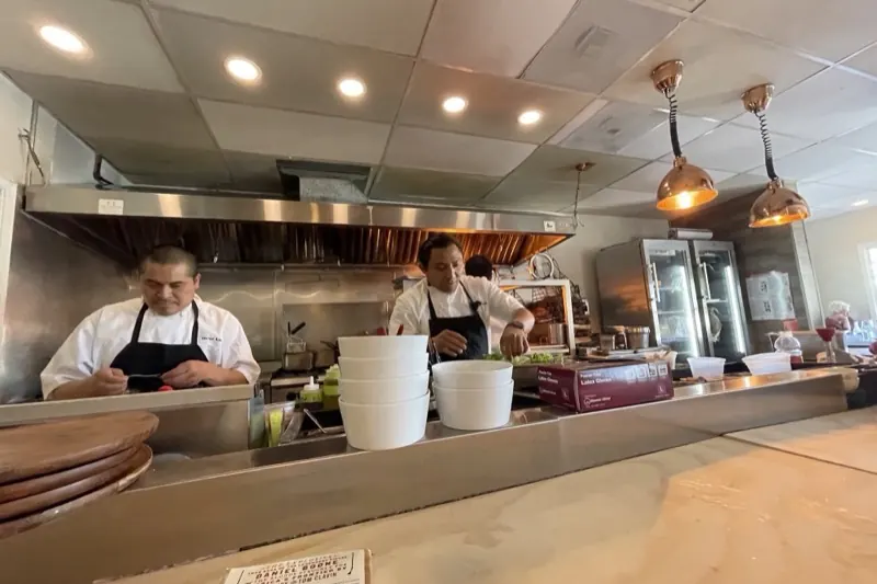 Cuisiniers au travail dans la cuisine ouverte et lumineuse d'un restaurant